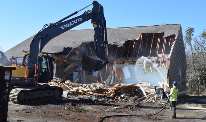 Heavy machinery demolishes the visitors center building at the Monomoy National Refuge headquarters on Morris Island. Water was being sprayed to prevent insulation from blowing away. TIM WOOD PHOTO