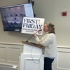 Judy Lindahl, executive director of the Orleans Chamber of Commerce, holds up a sign promoting “First Fridays” during a select board meeting on March 13.  RYAN  BRAY PHOTO