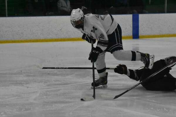 Monomoy junior Casey Huse skates around a Bishop Stang defender before scoring a second-period goal.