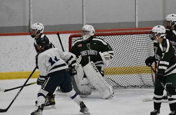 DY/CCT/CCA goaltender Will McAdams looks for the puck through a crowd of players in front of the goal.