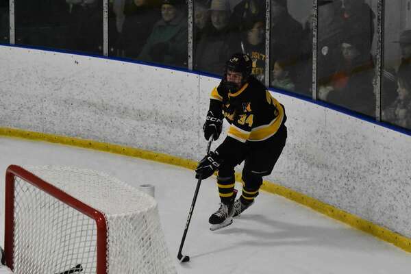 Nauset junior Logan Poulin plays the puck behind the Dolphins’ net.
