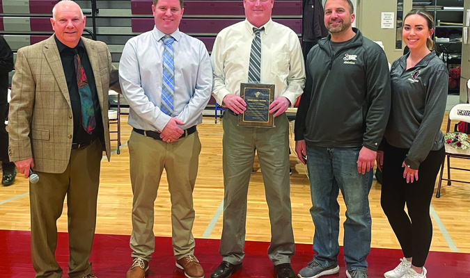 From left: Cape Cod Tech athletic director Alan Harrison, junior varsity coach Kevin Furey, varsity coach Brent Warren, freshman coach Alex Riker and athletic trainer Holly Mastronardi pose for a photo after presenting Warren with a plaque commemorating his 20-year coaching career before the team’s final game of the season. BRAD JOYAL PHOTOS