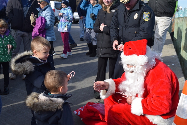 Santa hands out candy canes after arriving at the fish pier last year. He’ll arrive for his annual visit this Sunday, Dec. 3, at 1 p.m. FILE PHOTO